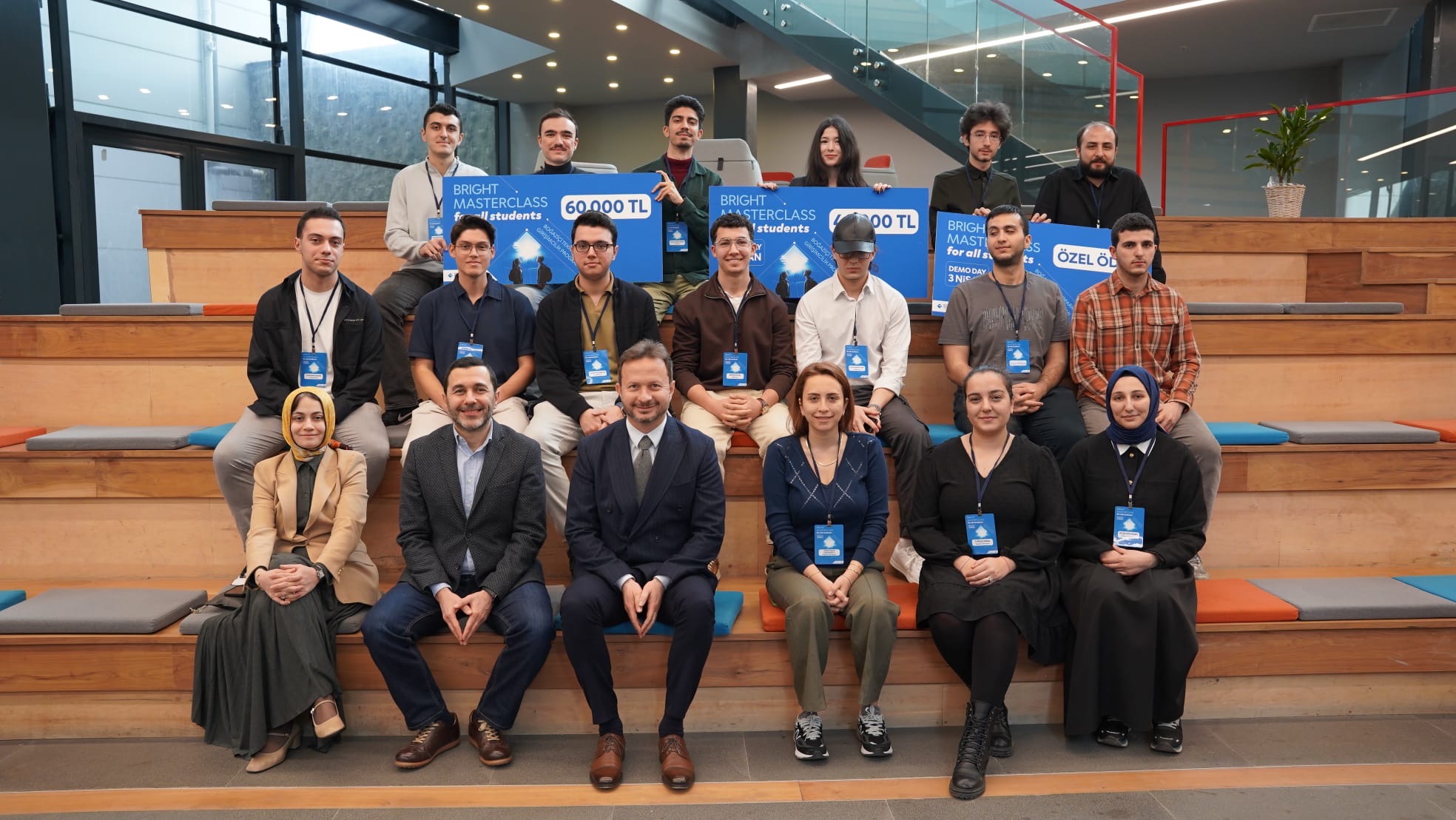 Tera Map Türkiye İstanbul etkinlik eventi Foligno Italia Tera Holding — Bright Masterclass awards group photo on wooden bleachers in İstanbul holding 60.000 TL 40.000 TL and Özel Ödül banners from Boğaziçi entrepreneurship eventi