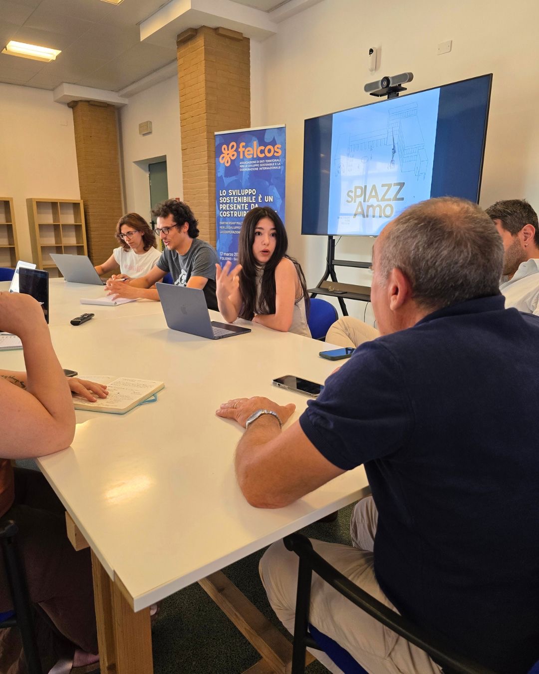 Tera Map Türkiye İstanbul etkinlik eventi Foligno Italia Tera Holding — FELCOS Foligno Italia sPIAZZ Amo sustainable development workshop eventi around a meeting table with laptops notebooks and blue association banner