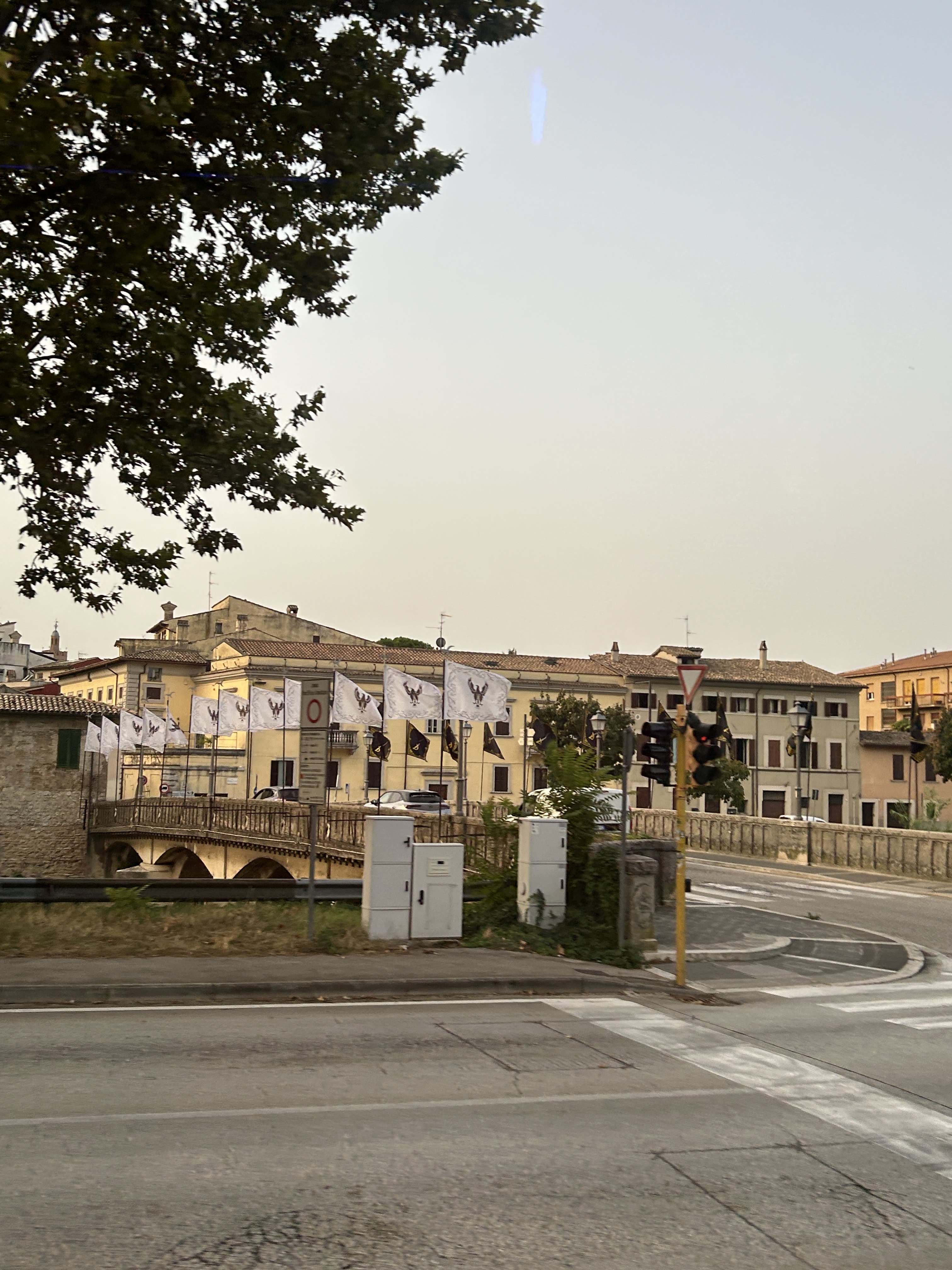 Tera Map Türkiye İstanbul etkinlik eventi Foligno Italia Tera Holding — Foligno Italia historic stone bridge lined with Giostra della Quintana heraldic eagle flags capturing the city backdrop of Tera Map Tera Holding international eventi